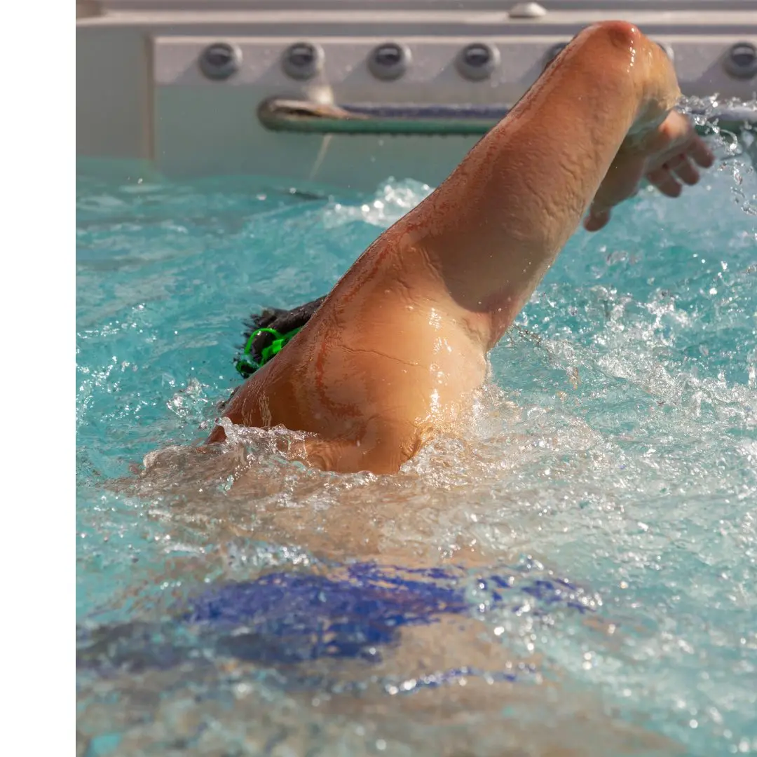 A man swims towards the current of his swim spa.